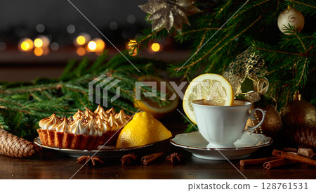 Meringue lemon tart and cup of tea on a wooden table. Meringue lemon tart and cup of tea on a wooden table. 128761531