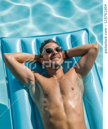 Man relaxing on blue inflatable pool float under sunlight enjoying summer leisure time 128761804