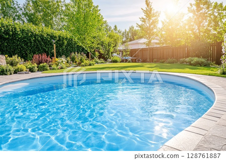 Sparkling swimming pool surrounded by lush greenery and vibrant flowers in a sunny backyard 128761887