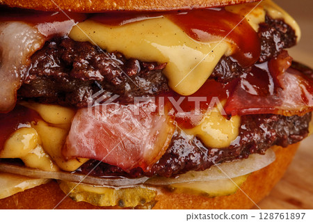 Delicious burger dripping with melted cheddar cheese and barbecue sauce Delicious burger dripping with melted cheddar cheese and barbecue sauce 128761897