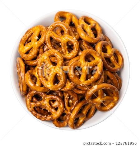 Small traditional beer pretzels with salt in a white ceramic bowl isolated on white background 128761956