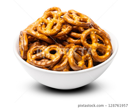 Small traditional beer pretzels with salt in a white ceramic bowl isolated on white background 128761957