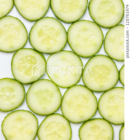 Background created from green ripe natural organic cucumber sliced into circles on white background Background created from green ripe natural organic cucumber sliced into circles on white background 128761974