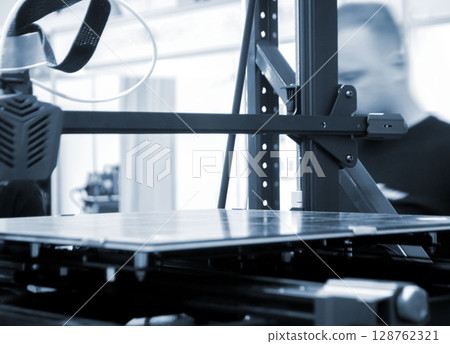 3D printer. Working surface desktop of 3D printer. Empty work surface of non-working 3D printer. Print head printer. Additive progressive technology. Modern new printing industry. Blue color 128762321