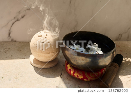 Zen Meditation Setup. A serene scene with a smoke sphere and singing bowl with flowers 128762903