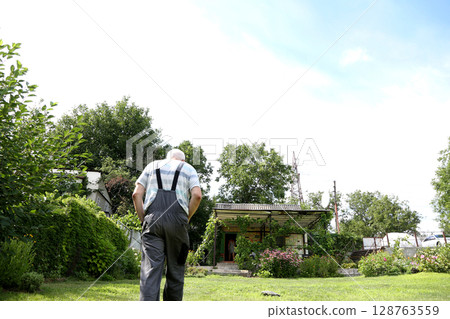 Man walking on lawn in country house Man walking on lawn in country house 128763559