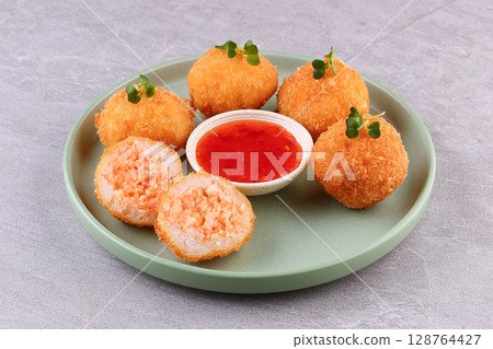 Crispy Salmon Rice Balls with Sweet Chili Sauce on Green Plate Crispy Salmon Rice Balls with Sweet Chili Sauce on Green Plate 128764427