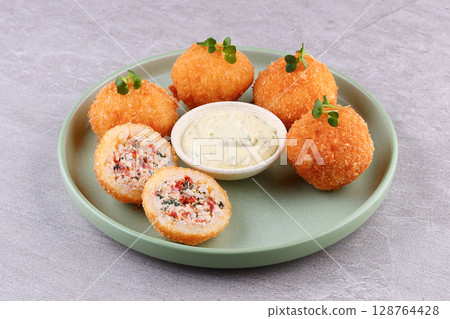 Crispy Tuna Rice Croquettes with Herb Mayo Dip on Green Plate 128764428