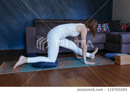 woman doing Half Splits pose yoga at home woman doing Half Splits pose yoga at home 128765089