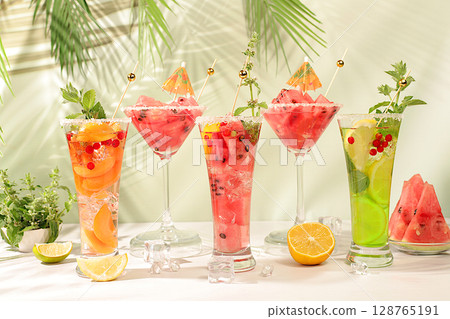 Modern still life with alcoholic cocktail of watermelon, apricot lemon, ice, tequila, vodka and mint on elegant background, minimalist concept for bar, Spanish sangria recipe, advertising banner Modern still life with alcoholic cocktail of watermelon, apricot lemon, ice, tequila, vodka and mint on elegant background, minimalist concept for bar, Spanish sangria recipe, advertising banner 128765191
