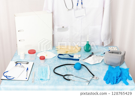 A collection of objects, medical equipment, instruments, supplies and documents located at a medical examination room. The medical items at the place of work of a doctor. Healthcare, medicine concepts 128765429