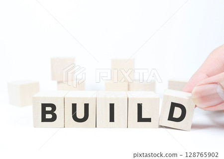 The word BUILD, which represents construction with wooden blocks, and building blocks in the background 128765902