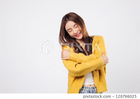 Hug yourself with pride, hug gently with love. A confident woman stands peacefully with arms over shoulders, showing a lifestyle of calm and carefree confidence. isolated white background Hug yourself with pride, hug gently with love. A confident woman stands peacefully with arms over shoulders, showing a lifestyle of calm and carefree confidence. isolated white background 128766025