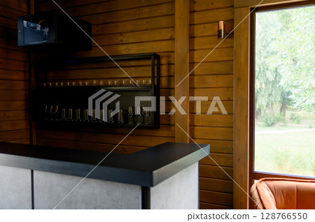 Bar counter with a shelf for glasses in a wooden interior Bar counter with a shelf for glasses in a wooden interior 128766550