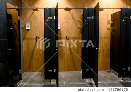Modern shower cabin design with wooden panels and chrome accessories 128766576
