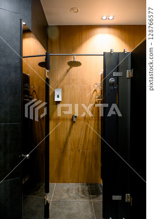 Modern shower cabin design with wooden panels and chrome accessories 128766577