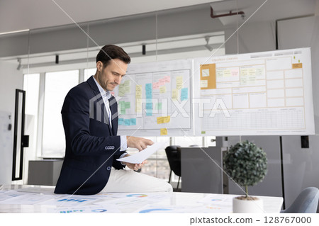 Serious businessman dressed in suit review business strategy documents 128767000