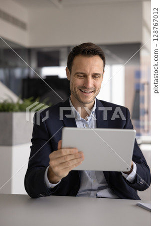 Executive manager reviewing electronic services using management apps on tablet 128767012