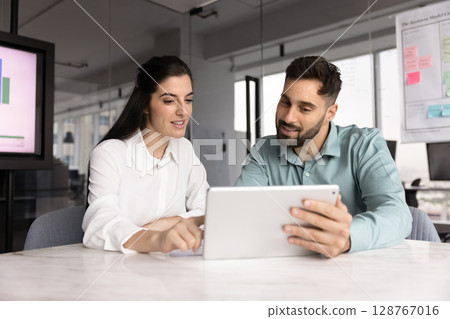 Two Latin teammates working on joint task using digital tablet 128767016