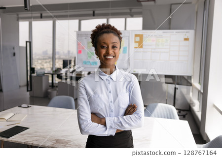 Portrait of young African businesswoman posing in conference room 128767164