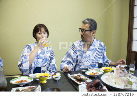 A family in yukata eating at a ryokan A family in yukata eating at a ryokan 128767219