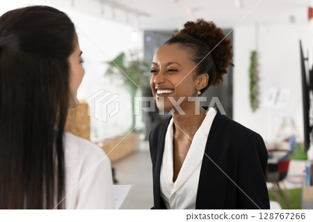 Happy woman enjoying friendly conversation during break in coworking space 128767266