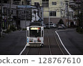 [Logo, company name and number blurred] Tram climbing a hill, following behind 128767610