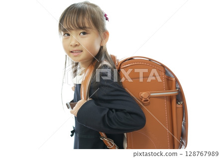 一個一年級的女孩背著書包走路上學 一個一年級的女孩背著書包走路上學 128767989