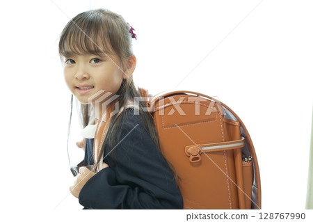一個一年級的女孩背著書包走路上學 一個一年級的女孩背著書包走路上學 128767990