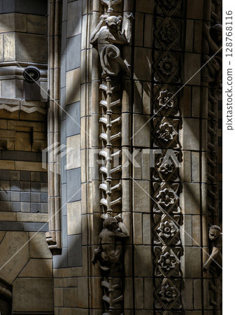 Sunlight illuminating intricate stone carvings and decorative elements on the columns and walls. 128768116