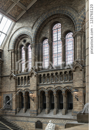 The intricate stained glass are set within richly detailed stonework walls, allowing natural light to illuminate the Hintze Hall at the Natural History Museum. 128768120