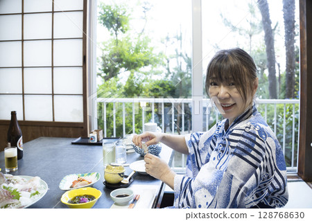 A woman in a yukata eating at a ryokan A woman in a yukata eating at a ryokan 128768630