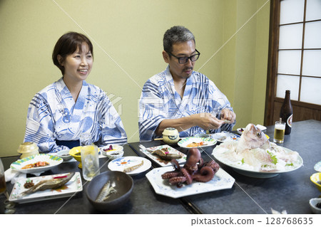 A family in yukata eating at a ryokan A family in yukata eating at a ryokan 128768635
