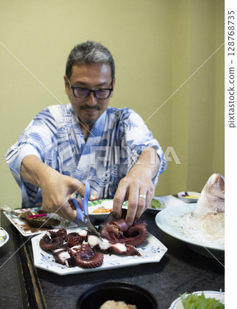 A man eating at a hotel 128768735