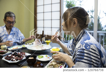 A couple in yukata eating at a ryokan A couple in yukata eating at a ryokan 128768738