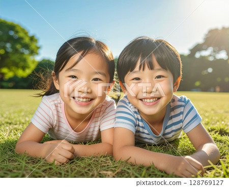 微笑的孩子躺在公園的草地上 微笑的孩子躺在公園的草地上 128769127