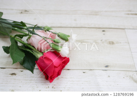 白色木質背景上一束紅色、粉紅色和白色的玫瑰和康乃馨 128769196
