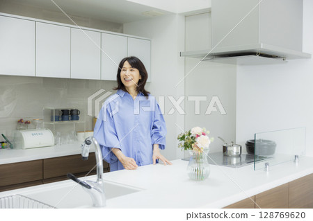 Woman holding a vase in the kitchen 128769620
