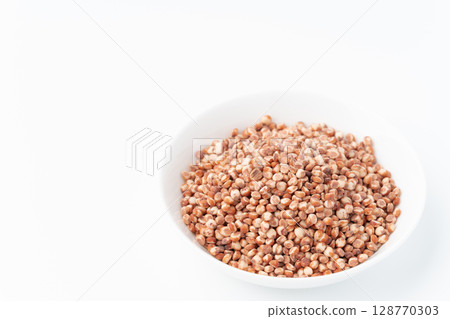 Sorghum millet in a plate on a white background 128770303