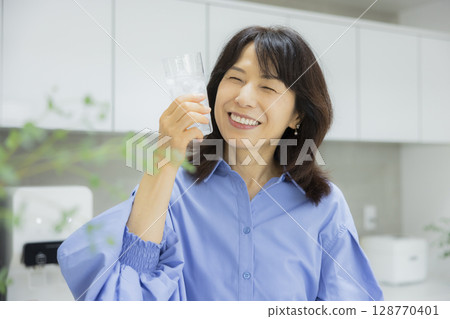 一個女人在廚房喝水 128770401