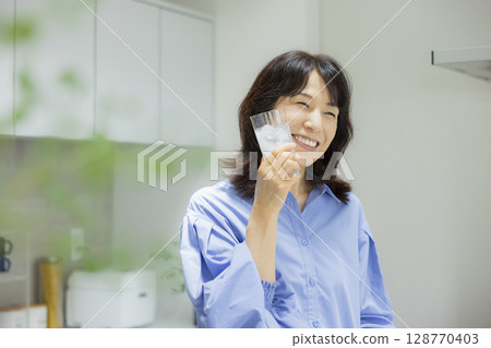 一個女人在廚房喝水 128770403
