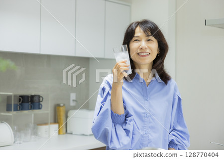 一個女人在廚房喝水 一個女人在廚房喝水 128770404