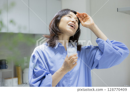一個女人在廚房喝水 一個女人在廚房喝水 128770409