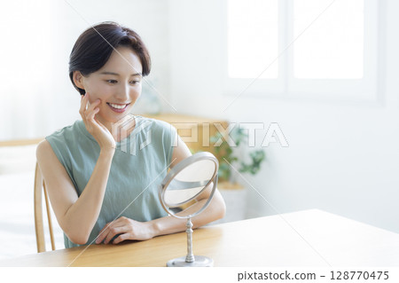 一位女士在臥室裡做皮膚護理 128770475