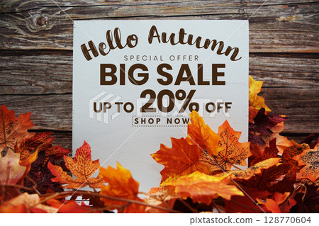 Hello Autumn Big Sale 20% text with maple leaf decoration on wooden background 128770604