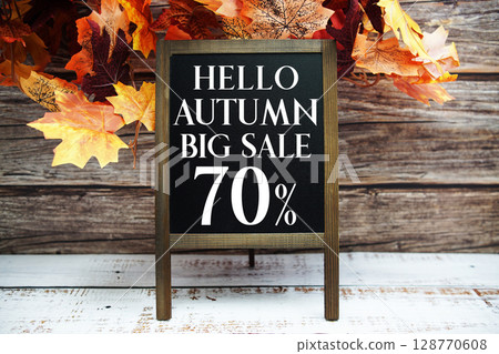Hello Autumn Big Sale 70% text with maple leaf decoration on wooden background Hello Autumn Big Sale 70% text with maple leaf decoration on wooden background 128770608