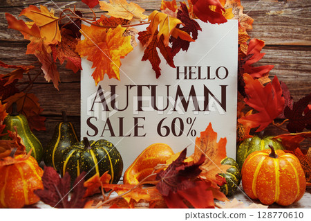 Hello Autumn Sale 60% text with maple leaf decoration on wooden background Hello Autumn Sale 60% text with maple leaf decoration on wooden background 128770610