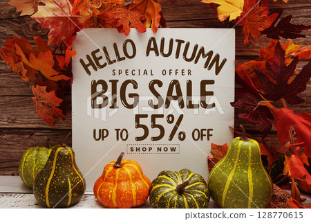Hello Autumn Big Sale 55% text with maple leaf decoration on wooden background 128770615