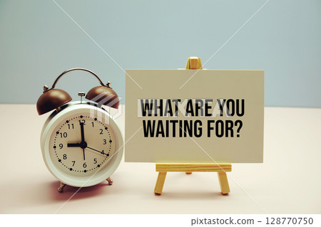What are your waiting for? text on paper card with alarm clock on pink background 128770750