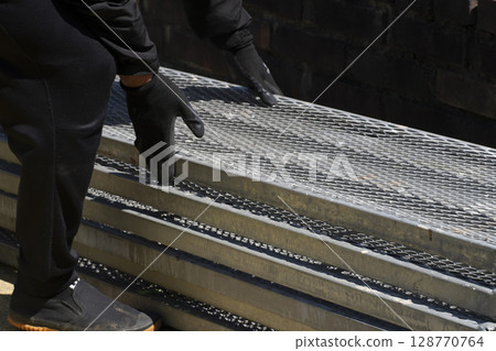 Workers assembling scaffolding 128770764